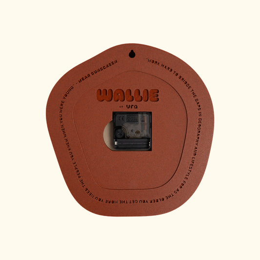 A terracotta brown circular WALLIE clock branded 'WALLIE by URA'. The product is displayed on a solid cream background. Made by Ura Watches / EON TIME