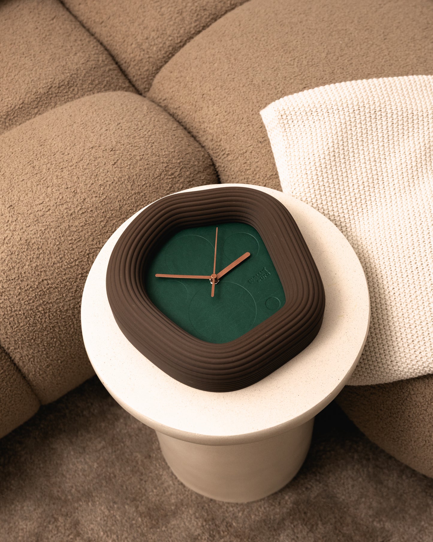 Decorative Wallie clock with a brown and green design on a white marble base. Made by Ura watches / EON TIME