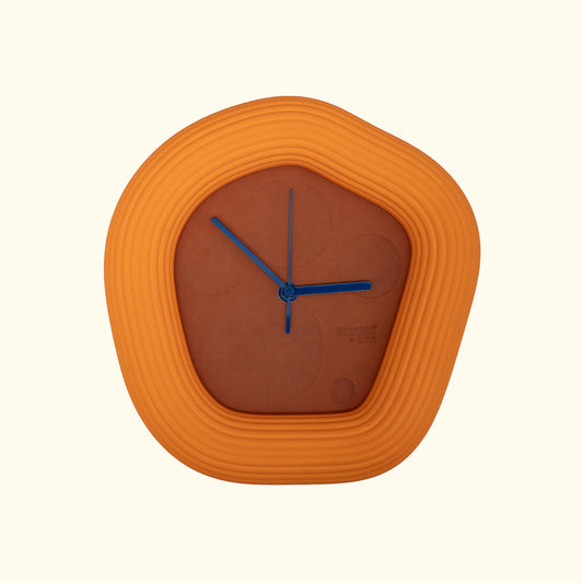 Orange Wallie wall clock with blue hands on a off white background. Made by Ura Watches / EON TIME