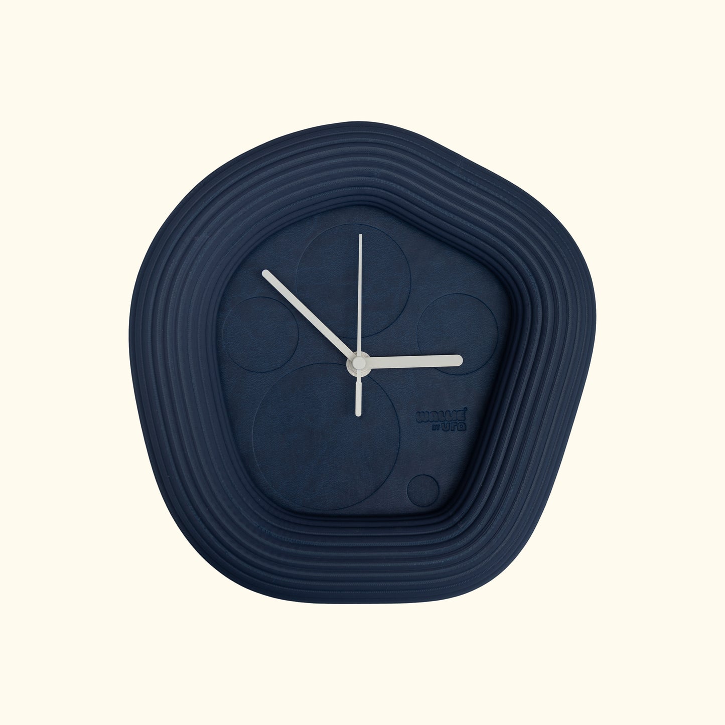 Blue wall clock with white hands on a off white background