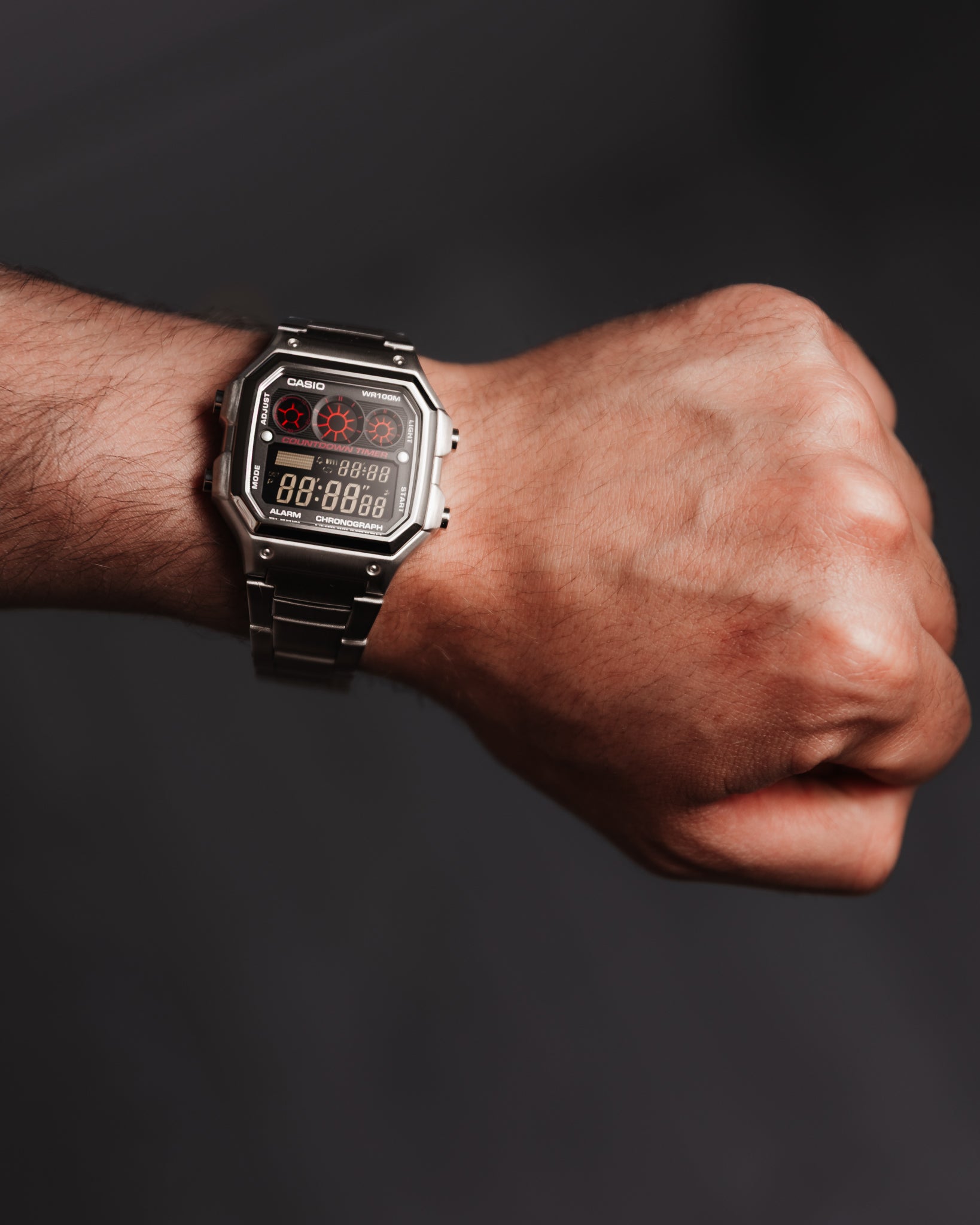 EON Redline Full Metal AE-1300 custom Casio digital watch with red and black display, stainless steel case and bracelet, worn on wrist.

